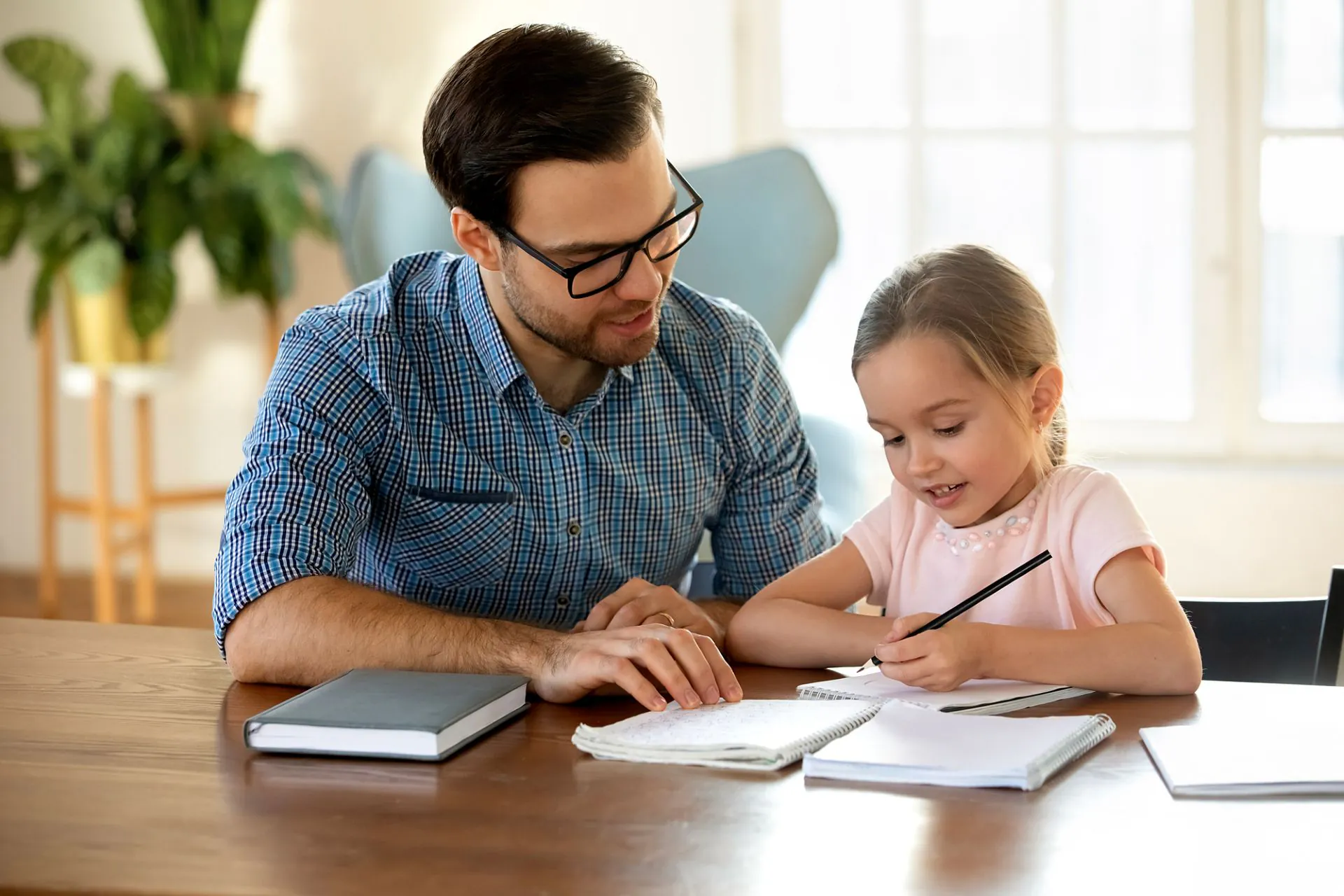 A parent helping a child with schoolwork at home — Roots Home Tutors